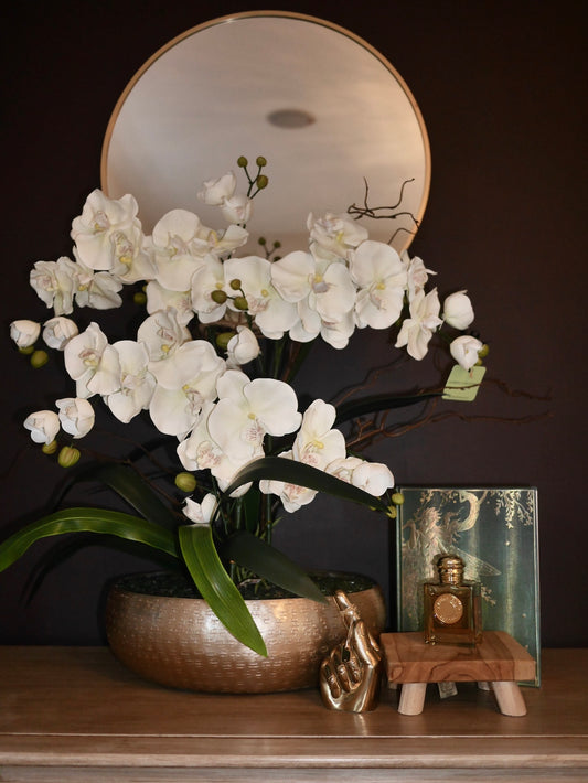 Crème Blush Orchid bespoke faux orchid arrangement with rose quartz crystal bed styled in a luxury interior setting