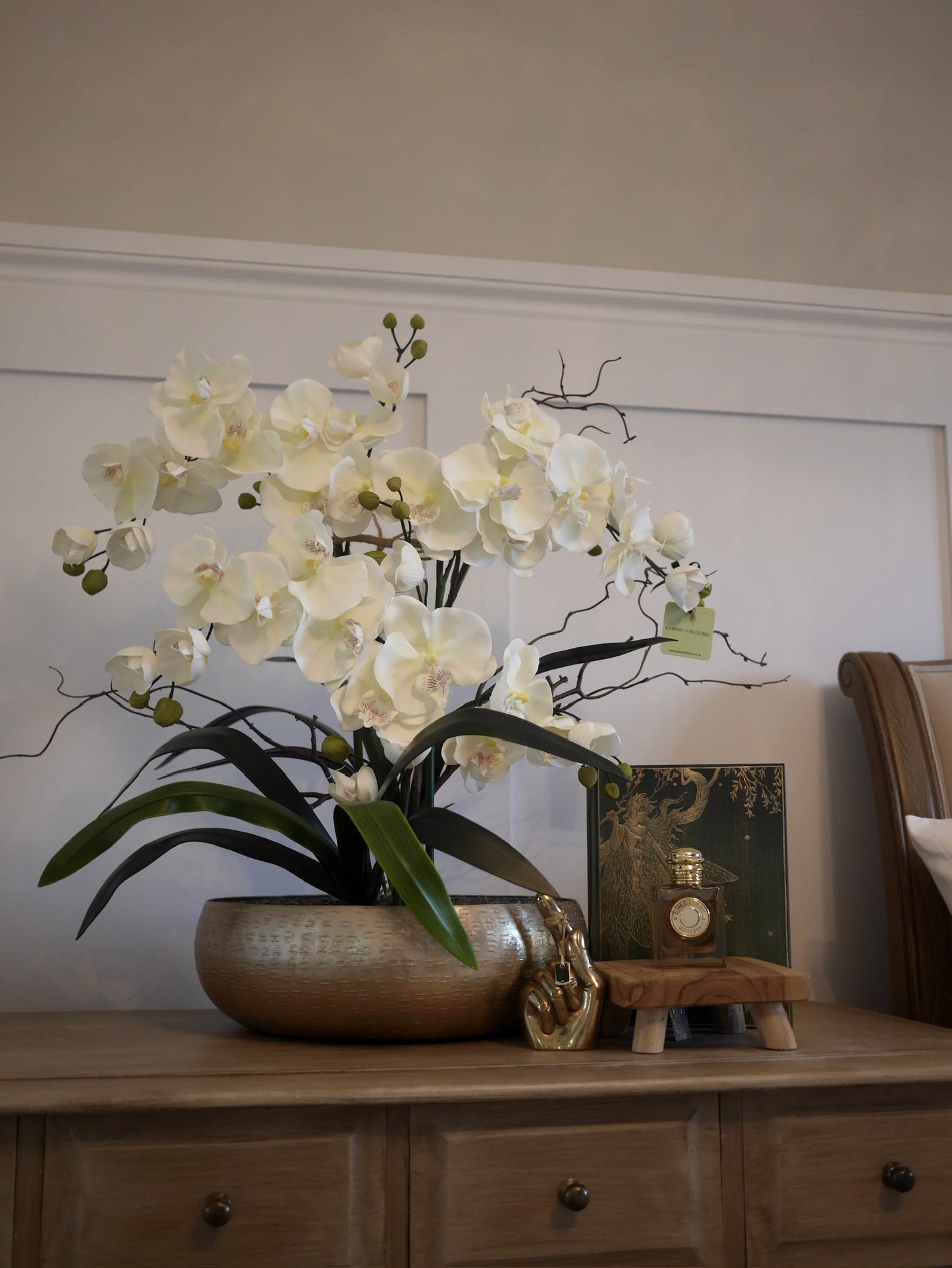 Crème Elite Orchid bespoke faux orchid arrangement with green aventurine crystal bed styled in a luxury interior setting