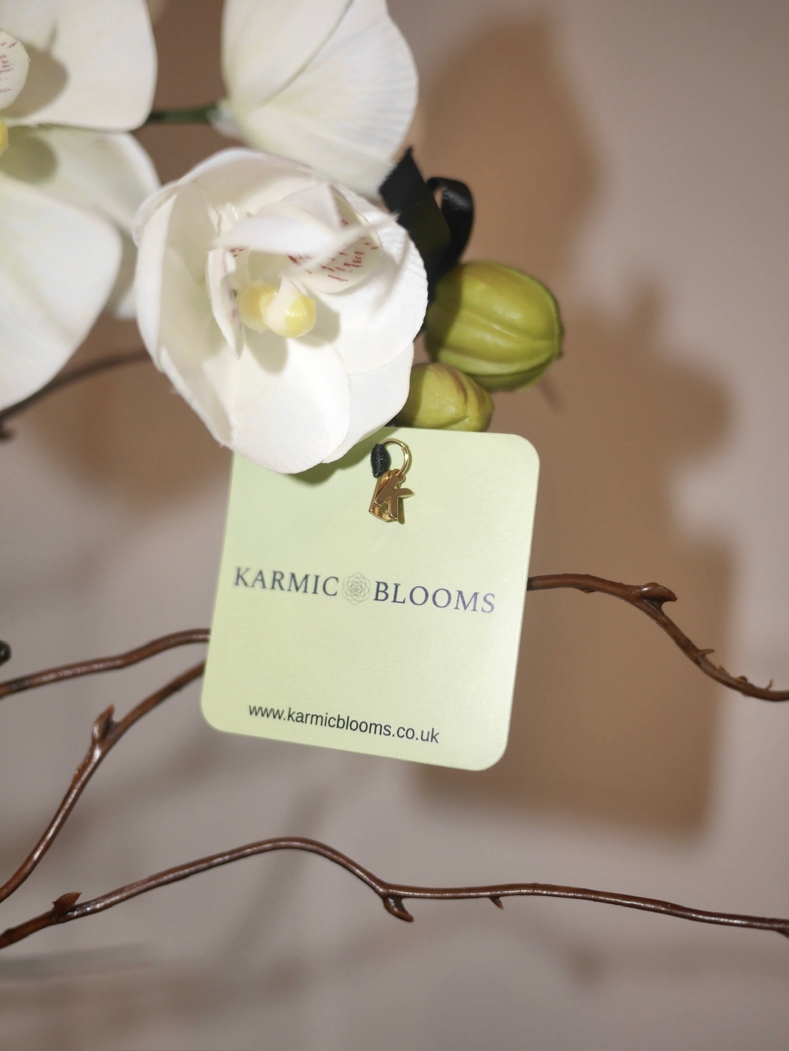 Crème Noir Orchid close up of Karmic Blooms branded label on luxury faux orchid arrangement
