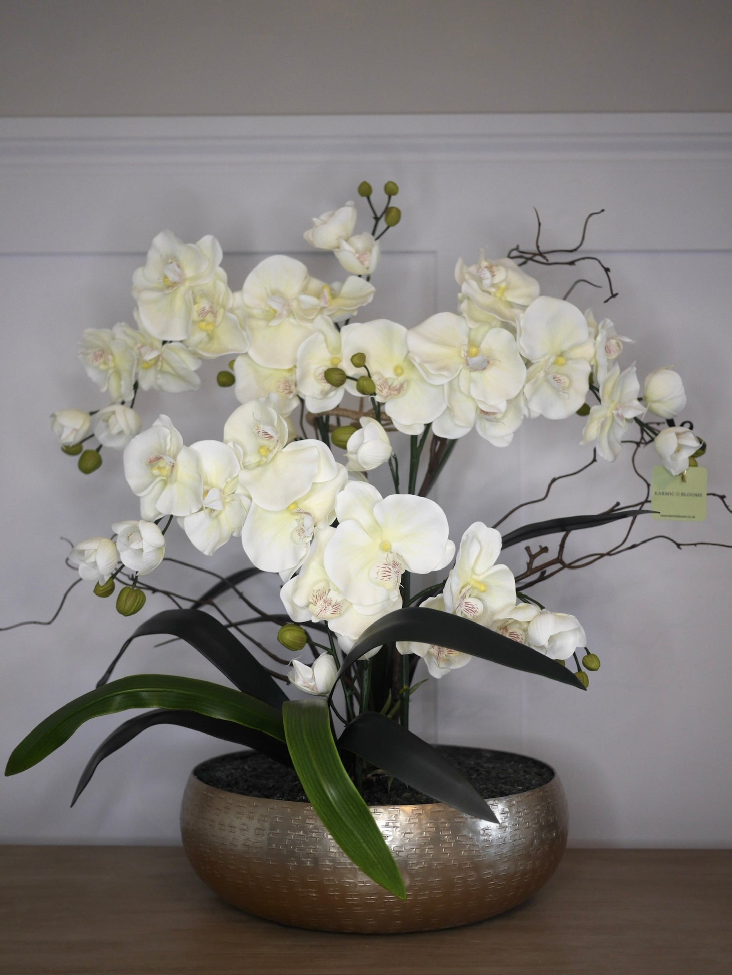 Crème Noir Orchid bespoke faux orchid arrangement with dark crystal bed styled in a luxury interior setting